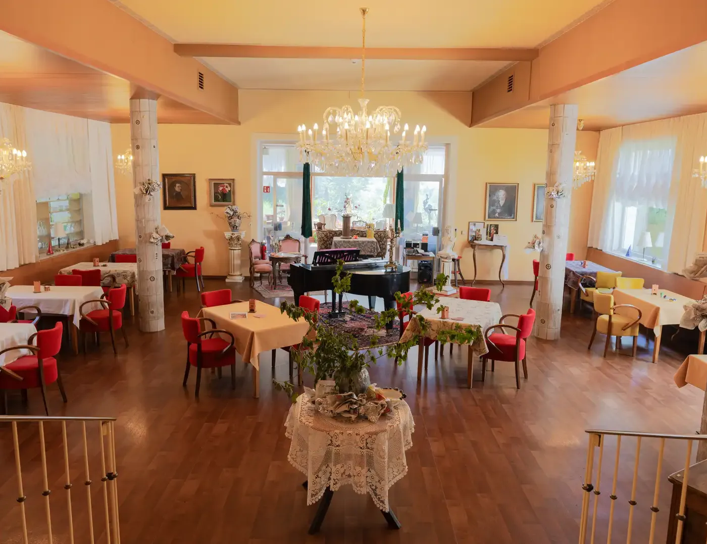 Festsaal mit Kronleuchter und Flügel in der Seniorenresidenz Ghersburg
