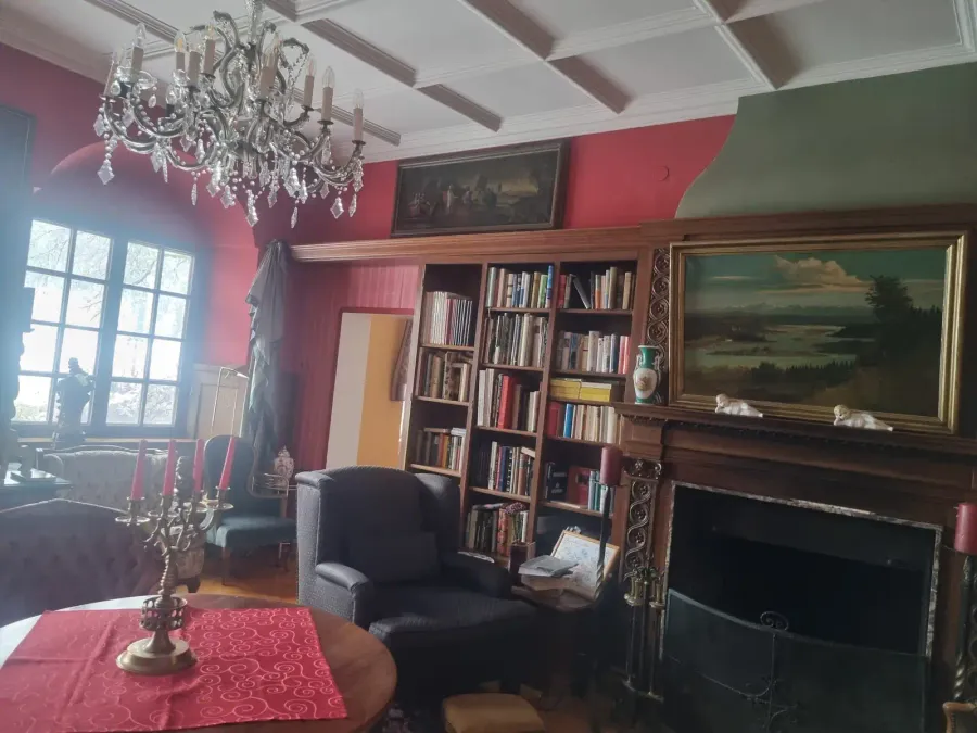 Bibliothek mit Kamin und Kronleuchter in der Villa Bruneck