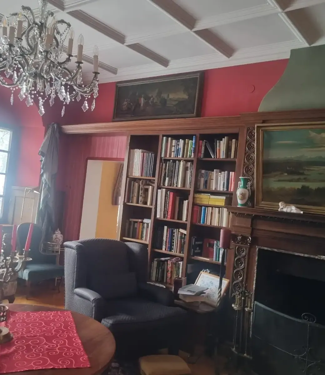 Bibliothek mit Kamin und Kronleuchter in der Villa Bruneck